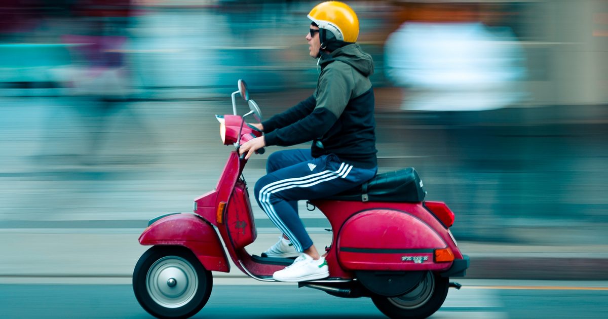 Hombre andando en moto, fondo desenfocado como efecto de la velocidad.