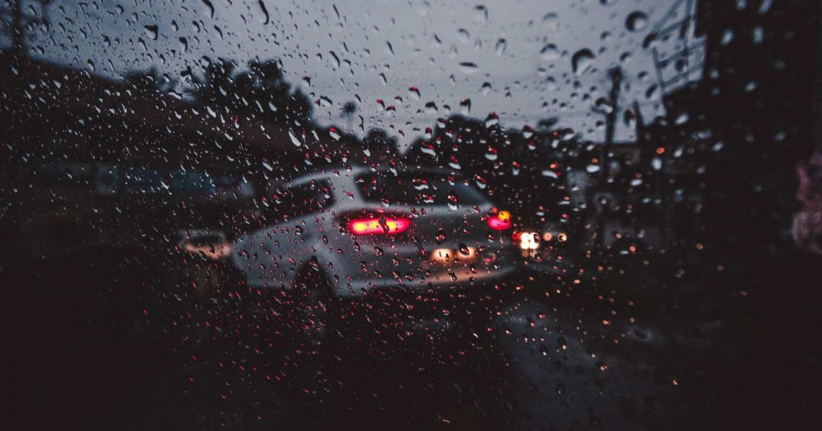 Auto en día lluvioso con luces traseras encendidas