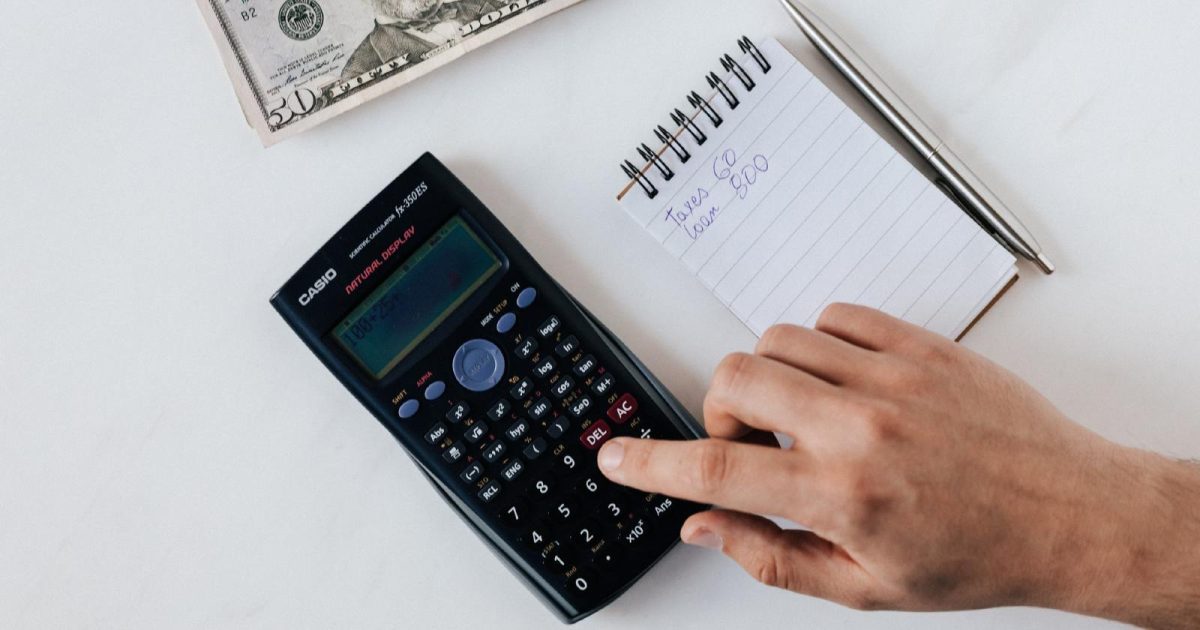 imagen de una calculadora, billetes y cuaderno con cálculos matemáticos
