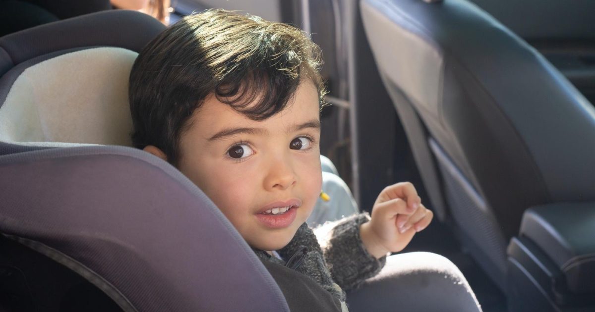 foto de un niño sentado en su asiento para niños adentro de un auto