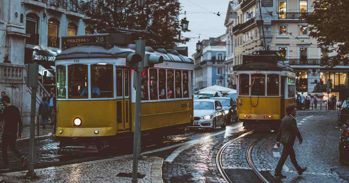 foto de una ciudad en Portugal dónde hay trenes y personas caminando luego de un día lluvioso