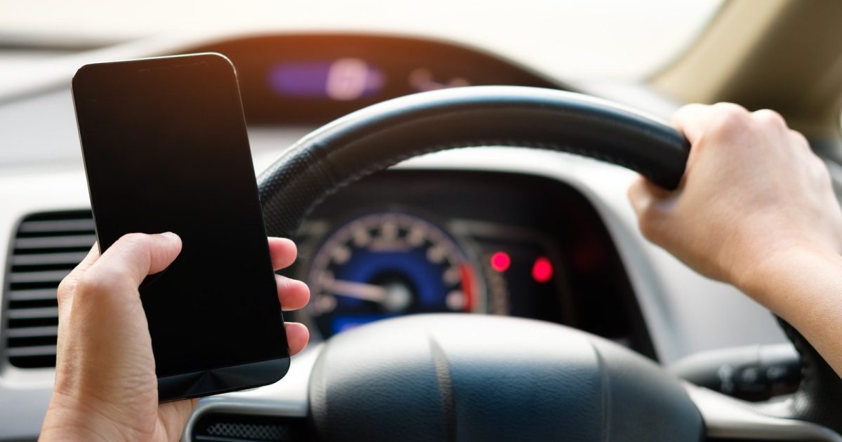 foto de alguien sosteniendo un celular mientras está conduciendo