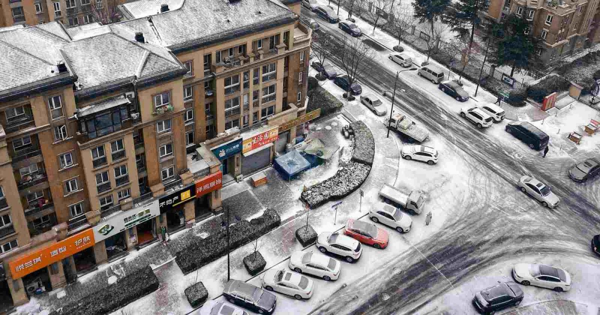 foto de las calles de una ciudad heladas y con hielo alrededor, además de varios autos estacionados