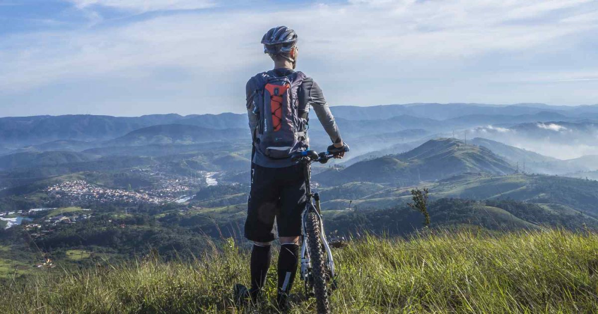 foto de un ciclista mirando el horizonte con su bicicleta al lado