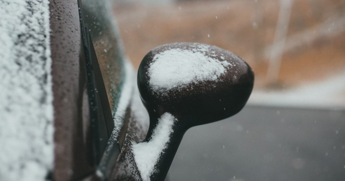 foto de un espejo retrovisor tapado en nieve