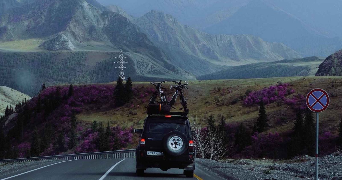 foto de un jeep transportando bicicletas mientras va en movimiento por carretera