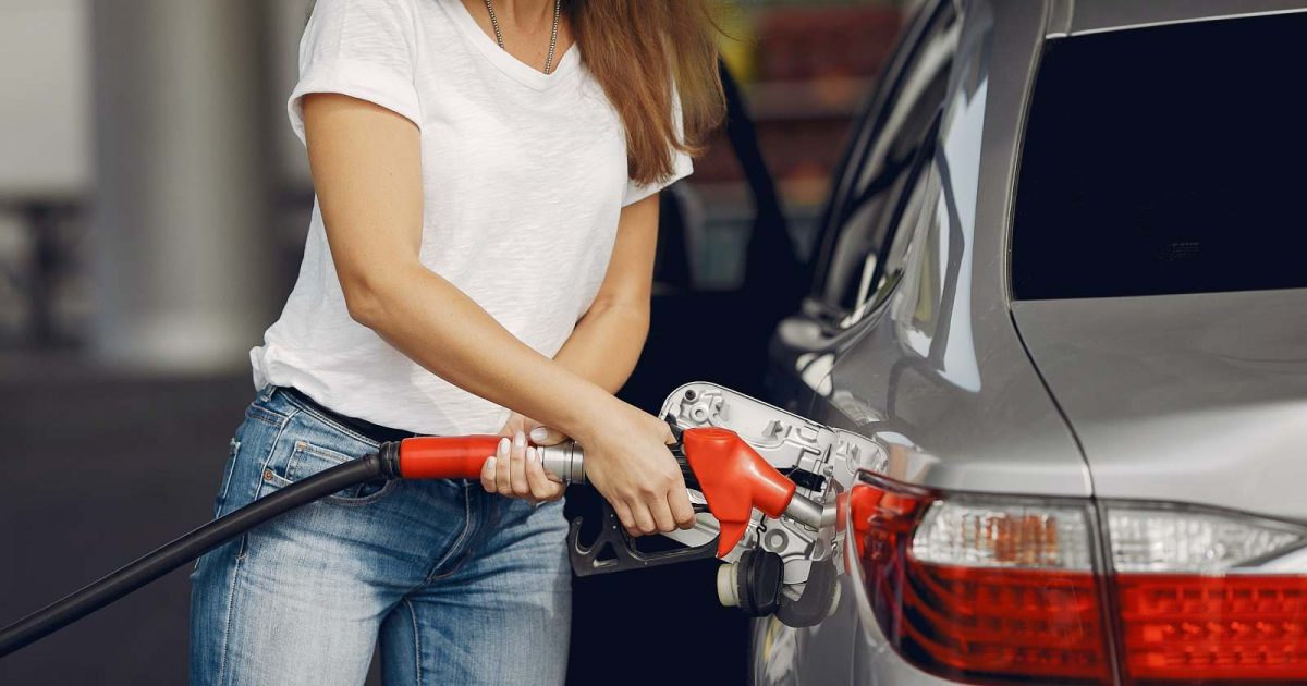 foto de una mujer echando combustible a su vehículo