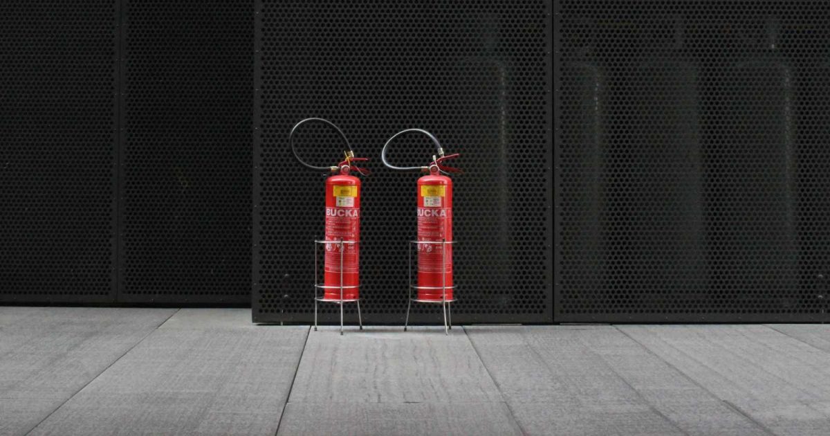 foto de dos extintores de fuego sobre el piso de una habitación