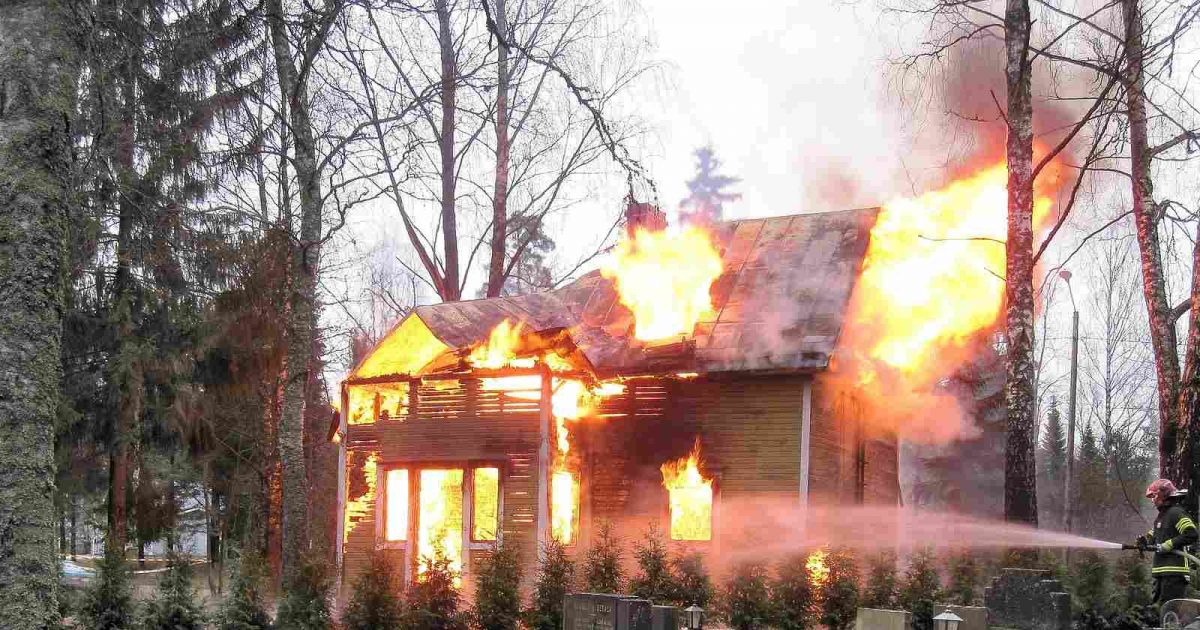 foto de un bombero apagando un incendio en una casa
